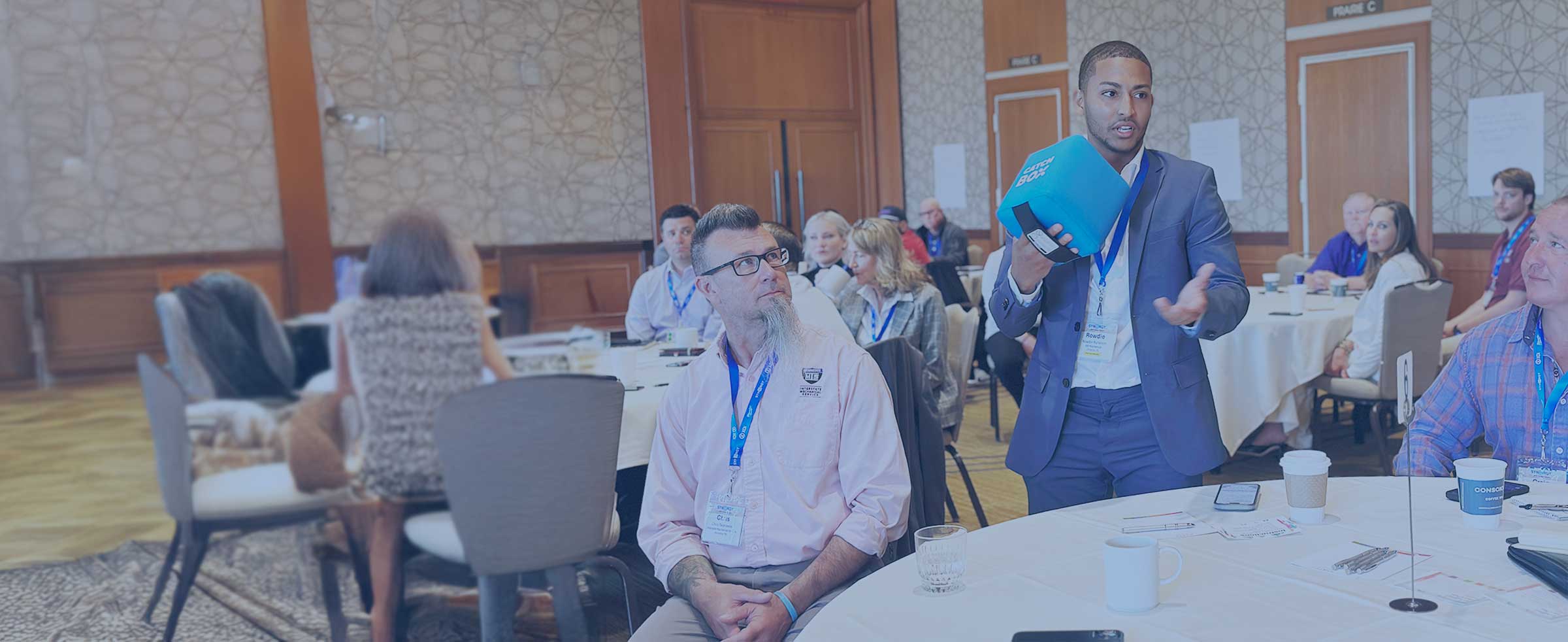 man engaging with room of people at conference